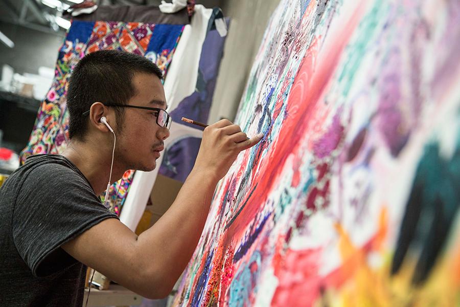 Artist Feng Zhijia works on a painting (Photo provided to China Daily)