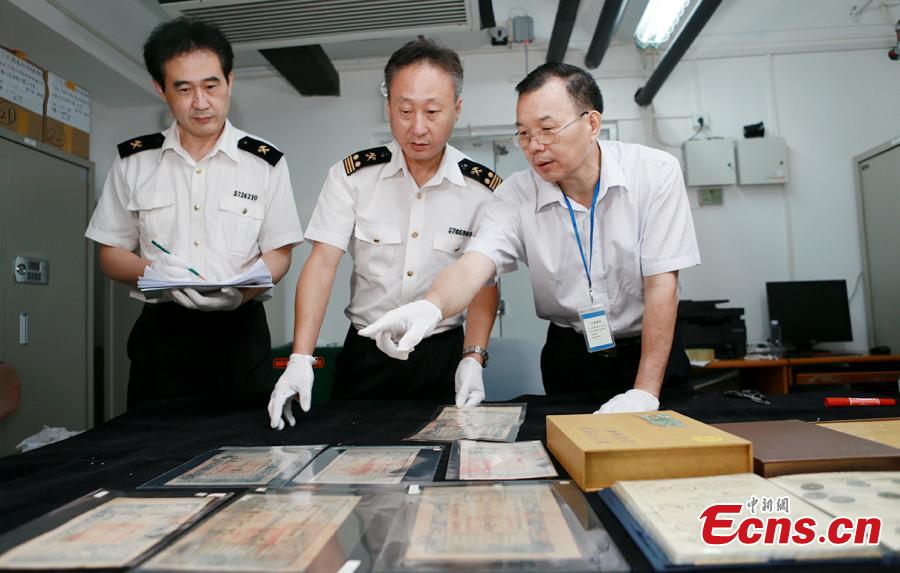 Customs officials show relics found in border checks at a handover ceremony in Guangdong Province, Sept. 6, 2018. Gongbei Customs handed over 157 cultural relics, including currency from the Warring States (475-221 B.C.) and Han Dynasty (206 BC ? 220 AD) periods, to Guangdong Provincial Cultural Relics Bureau. The relics were all Class I items under state protection and forbidden to be taken abroad. Among the findings was a well-preserved account book of the Qing Dynasty (1368-1644), thought to be of great historical value. (Photo: China News Service/Yu Bo)