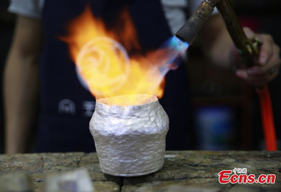 Yang Changgan makes a silver pot in his studio in Zhangjiajie City, Central China’s Hunan Province, Sept. 5, 2018. Yang, born in 1986 in Guizhou Province, was exposed to the craft of silverwork from an early age. After completing his bachelor’s degree at Nanchang Institute of Technology in 2010, he learned with Yang Guangbin, a master crafter of the silver ornaments of the Miao people. He then opened his own studio in Zhangjiajie in 2015, mainly developing silver pot products. Yang said it takes 10-15 days to make a silver pot as the process involves nearly 100 steps, including pounding, refining and wielding. Yang said his creations sell well in nearly 20 countries and regions. (Photo: China News Service/Wu Yongbing)