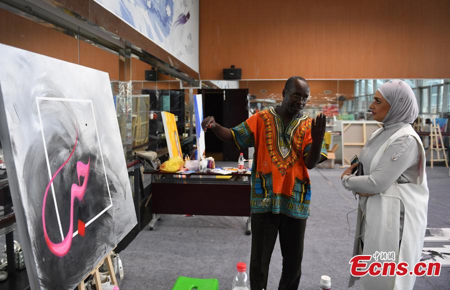 Two Arab artists talk during a tour of Hangzhou City, East China\'s Zhejiang Province, Sept. 6, 2018. Eleven Arabian artists in total visited the city in a cultural exchange program. (Photo: China News Service/Wang Gang)