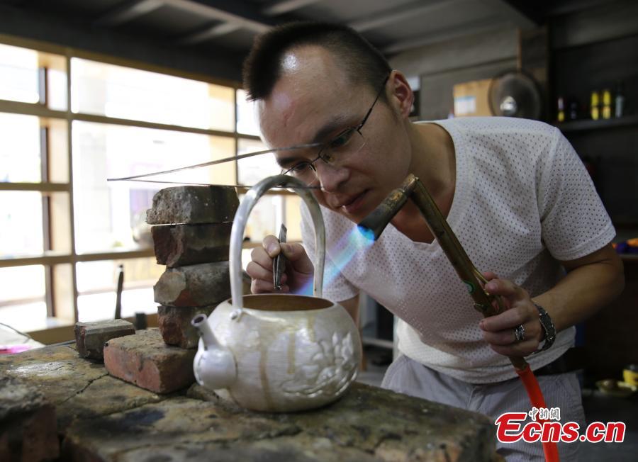 Yang Changgan makes a silver pot in his studio in Zhangjiajie City, Central China’s Hunan Province, Sept. 5, 2018. Yang, born in 1986 in Guizhou Province, was exposed to the craft of silverwork from an early age. After completing his bachelor’s degree at Nanchang Institute of Technology in 2010, he learned with Yang Guangbin, a master crafter of the silver ornaments of the Miao people. He then opened his own studio in Zhangjiajie in 2015, mainly developing silver pot products. Yang said it takes 10-15 days to make a silver pot as the process involves nearly 100 steps, including pounding, refining and wielding. Yang said his creations sell well in nearly 20 countries and regions. (Photo: China News Service/Wu Yongbing)