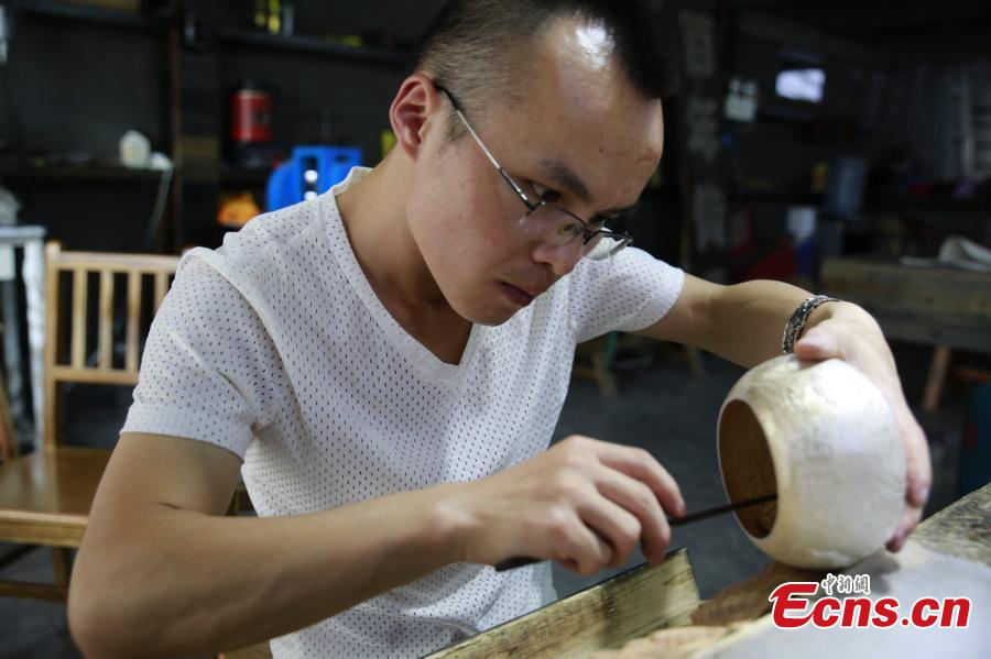 Yang Changgan makes a silver pot in his studio in Zhangjiajie City, Central China’s Hunan Province, Sept. 5, 2018. Yang, born in 1986 in Guizhou Province, was exposed to the craft of silverwork from an early age. After completing his bachelor’s degree at Nanchang Institute of Technology in 2010, he learned with Yang Guangbin, a master crafter of the silver ornaments of the Miao people. He then opened his own studio in Zhangjiajie in 2015, mainly developing silver pot products. Yang said it takes 10-15 days to make a silver pot as the process involves nearly 100 steps, including pounding, refining and wielding. Yang said his creations sell well in nearly 20 countries and regions. (Photo: China News Service/Wu Yongbing)