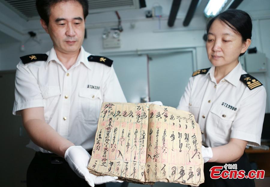 Customs officials show relics found in border checks at a handover ceremony in Guangdong Province, Sept. 6, 2018. Gongbei Customs handed over 157 cultural relics, including currency from the Warring States (475-221 B.C.) and Han Dynasty (206 BC ? 220 AD) periods, to Guangdong Provincial Cultural Relics Bureau. The relics were all Class I items under state protection and forbidden to be taken abroad. Among the findings was a well-preserved account book of the Qing Dynasty (1368-1644), thought to be of great historical value. (Photo: China News Service/Yu Bo)