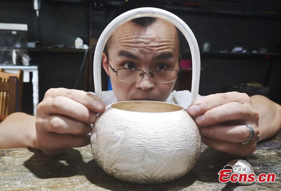 Yang Changgan makes a silver pot in his studio in Zhangjiajie City, Central China’s Hunan Province, Sept. 5, 2018. Yang, born in 1986 in Guizhou Province, was exposed to the craft of silverwork from an early age. After completing his bachelor’s degree at Nanchang Institute of Technology in 2010, he learned with Yang Guangbin, a master crafter of the silver ornaments of the Miao people. He then opened his own studio in Zhangjiajie in 2015, mainly developing silver pot products. Yang said it takes 10-15 days to make a silver pot as the process involves nearly 100 steps, including pounding, refining and wielding. Yang said his creations sell well in nearly 20 countries and regions. (Photo: China News Service/Wu Yongbing)