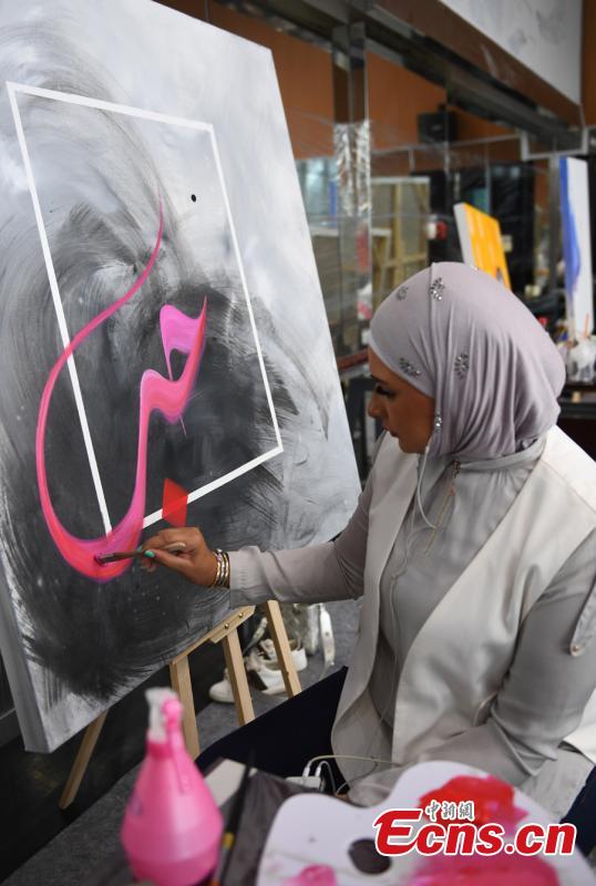 An artist draws a painting during a tour of Hangzhou City, East China\'s Zhejiang Province, Sept. 6, 2018. Eleven Arabian artists in total visited the city in a cultural exchange program. (Photo: China News Service/Wang Gang)
