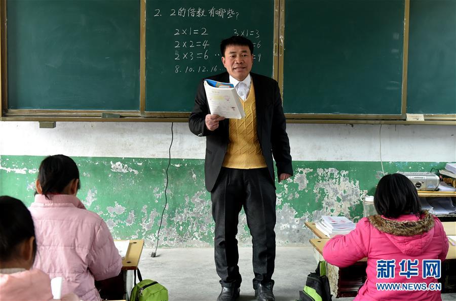 Zhang Yugun teaches in the Heihumiao village, Nanyang city of Henan Province, March 20, 2018. (Photo/Xinhua)
After graduation in 2001, Zhang Yugun sacrificed an opportunity to enjoy a better life in the city and instead to work in the poor countryside.
Over a 10-year period, Zhang has seen many teachers come and go in the Heihumiao village in a remote part of Central China\'s Henan province because of the poor conditions, but he has stayed on and made every effort to educate students and help them out of difficulties.
Zhang and his motorcycle keep ferrying textbooks and exercise books from the city to the school via rugged mountain roads. And to help those students whose parents have left the village to find work in the city, his wife quit her job to cook and clean for the students.