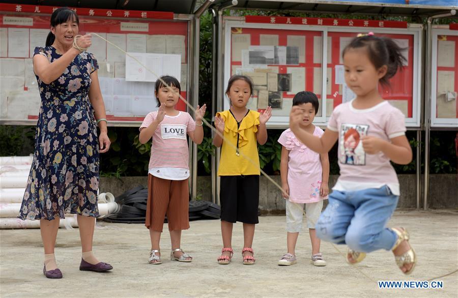 Jiang Xiulan participates in a PE class in Qingxi Central Primary School in Chaerlong village, Wushi town, Huangshan City of east China\'s Anhui Province, Sept. 7, 2018. Since 1983 when she began her career as a teacher, Jiang has been working in the \