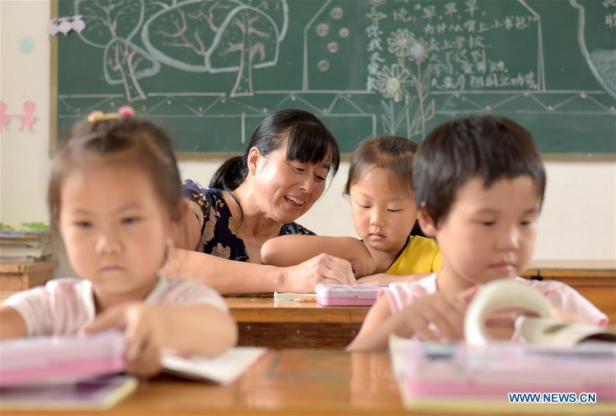 Jiang Xiulan explains as her students study in a class in Qingxi Central Primary School in Chaerlong village, Wushi town, Huangshan City of east China\'s Anhui Province, Sept. 7, 2018. Since 1983 when she began her career as a teacher, Jiang has been working in the \