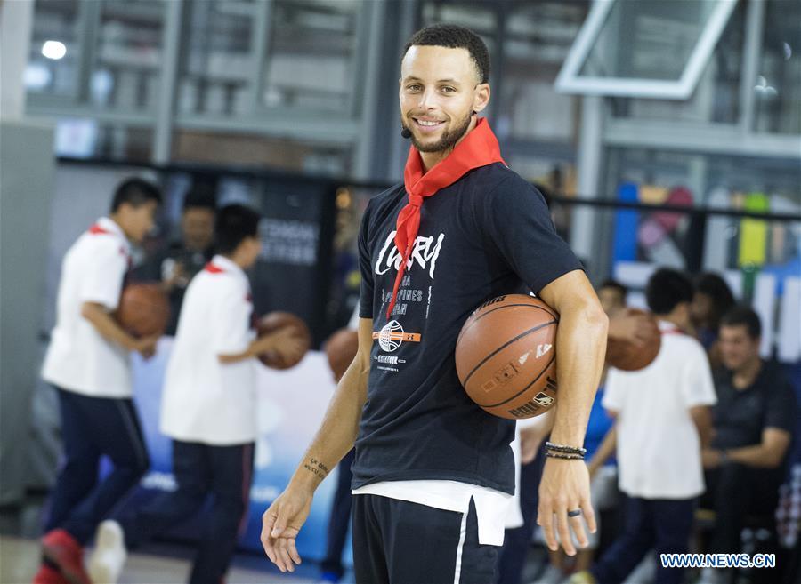NBA player Stephen Curry of Golden State Warriors reacts during a training session with young players of Middle School Attached to HUST (Huazhong University of Science and Technology) during his China Tour in Wuhan, central China\'s Hubei Province, Sept. 10, 2018. (Xinhua/Xiao Yijiu)
