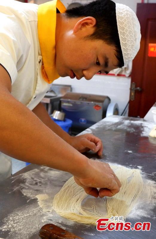 Mu Numa makes Lamian (hand-pulled noodles) in Hualong Hui Autonomous County, Northwest China’s Qinghai Province, Sept. 10, 2018. After years of practice, Ma is able to twist, stretch and fold the dough into strands thin enough to thread a needle. (Photo: China News Service/Li Juan)