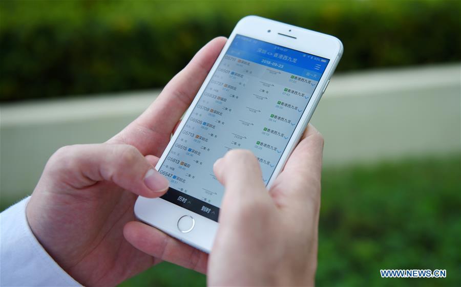 A citizen use a smartphone to search high-speed railway tickets from Shenzhen North Station to Hong Kong West Kowloon Station in Shenzhen, south China\'s Guangdong Province, Sept. 10, 2018. The Guangzhou-Shenzhen-Hong Kong high-speed railway will officially start operation on Sept. 23. The sale of the tickets began on Monday. (Xinhua/Mao Siqian)