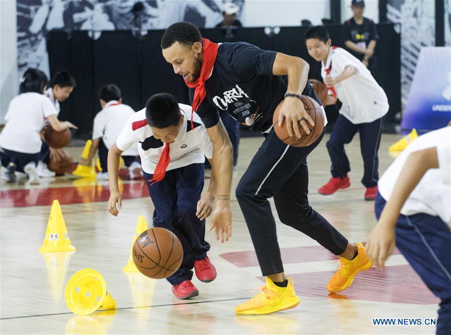 NBA player Stephen Curry of Golden State Warriors takes a training session with young players of Middle School Attached to HUST (Huazhong University of Science and Technology) during his China Tour in Wuhan, central China\'s Hubei Province, Sept. 10, 2018. (Xinhua/Xiao Yijiu)