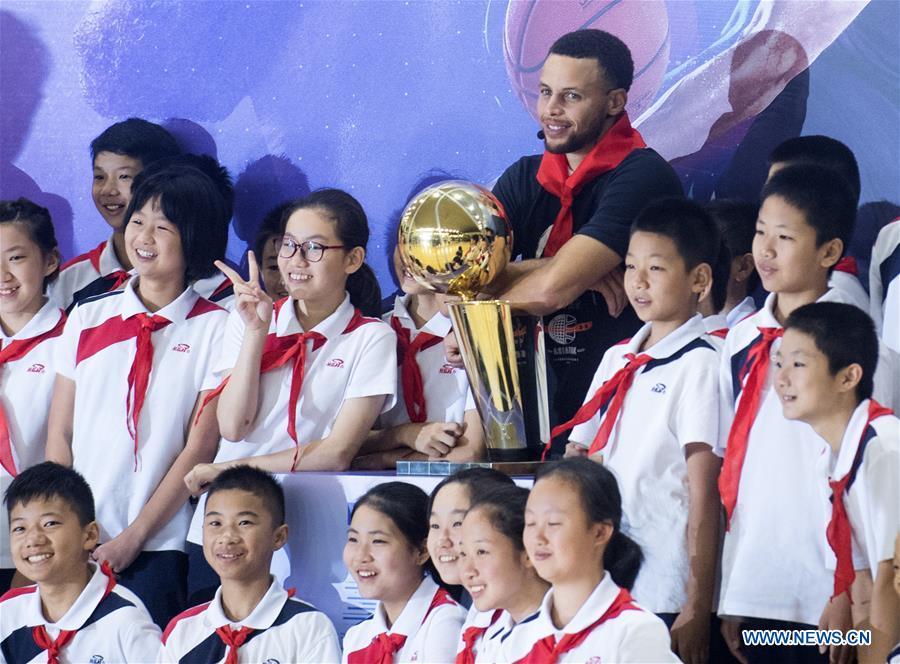 NBA player Stephen Curry of Golden State Warriors poses for photos with young players of Middle School Attached to HUST (Huazhong University of Science and Technology) during his China Tour in Wuhan, central China\'s Hubei Province, Sept. 10, 2018. (Xinhua/Xiao Yijiu)
