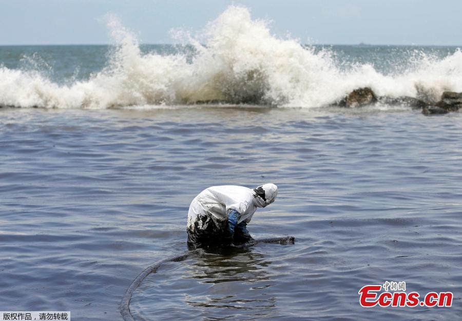 A member of the Sri Lankan coast guard removes oil from a beach after an oil spill in Uswetakeiyawa, Sri Lanka, Sept. 10, 2018. (Photo/Agencies)