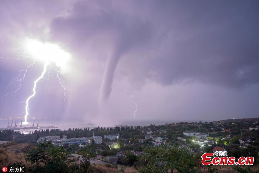 Photo taken by Andrei Sheliakin shows the rare tornadic waterspout in Crimea amid lightning. (Photo/IC)