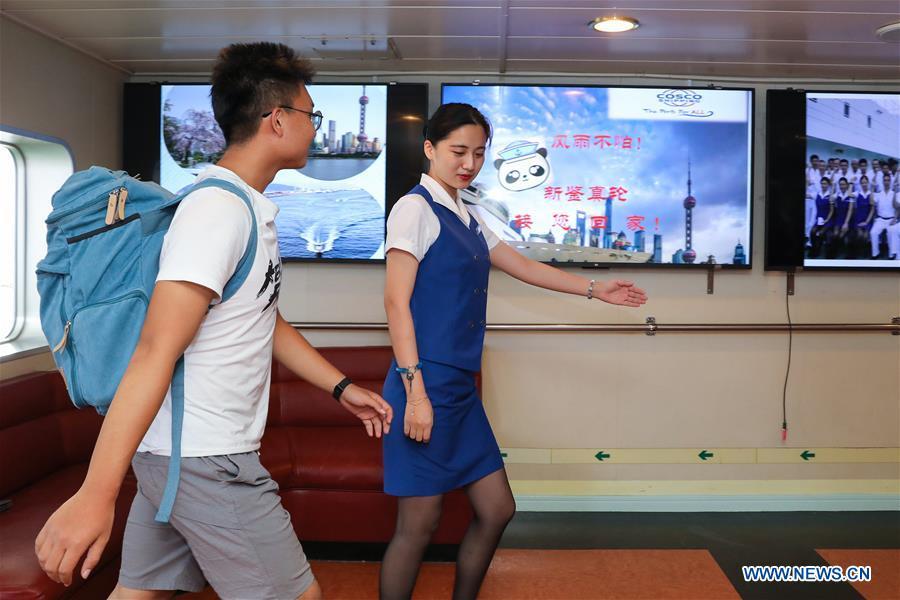 A staff member helps a Chinese passenger to board the ferry \