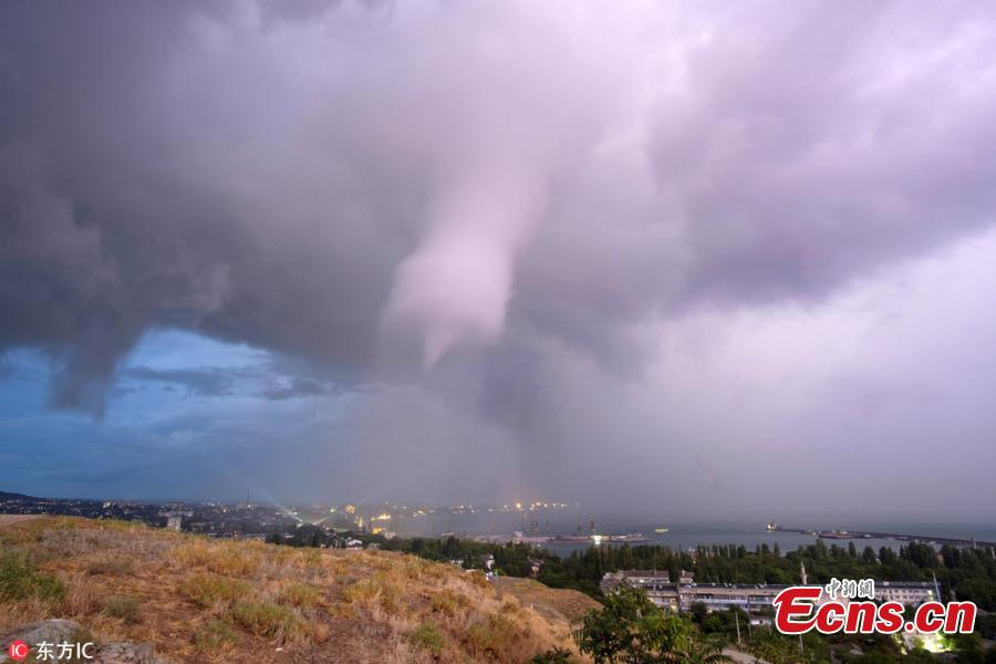 Photo taken by Andrei Sheliakin shows the rare tornadic waterspout in Crimea amid lightning. (Photo/IC)