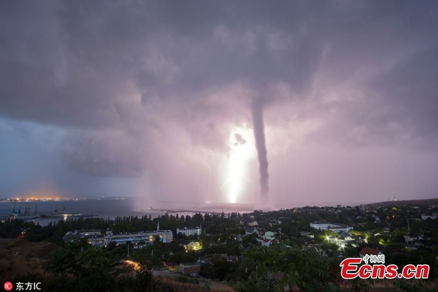 Photo taken by Andrei Sheliakin shows the rare tornadic waterspout in Crimea amid lightning. (Photo/IC)