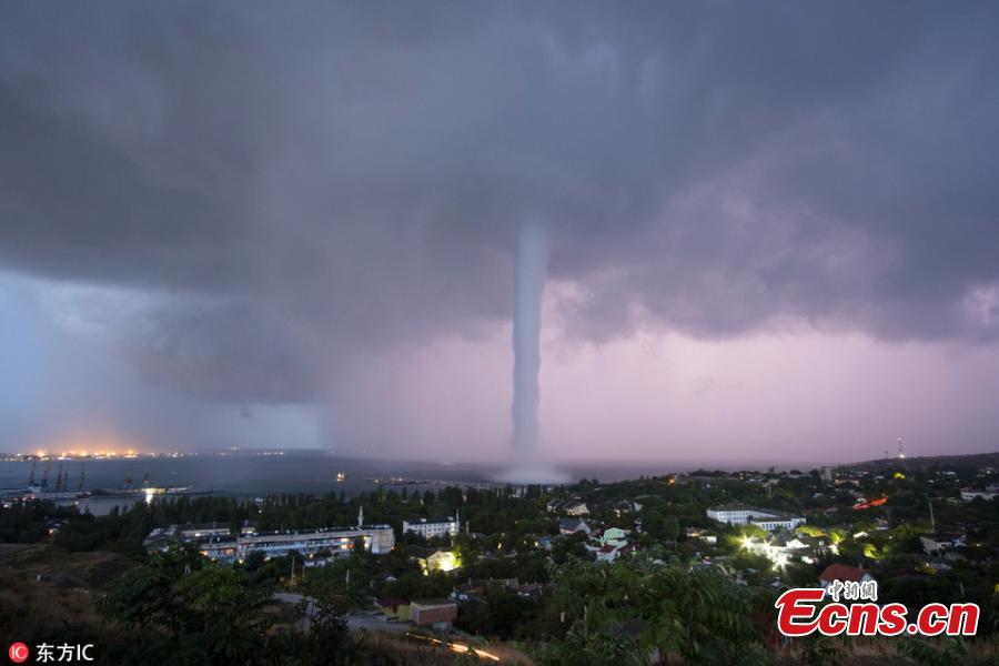 Photo taken by Andrei Sheliakin shows the rare tornadic waterspout in Crimea amid lightning. (Photo/IC)