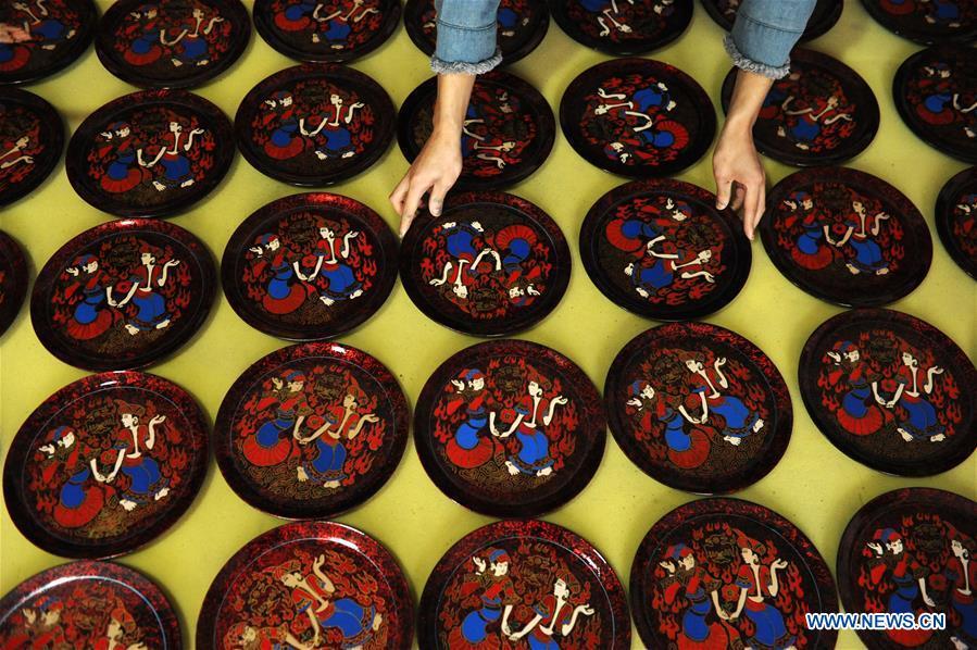 A craftsman dries lacquerworks in Dafang County, southwest China\'s Guizhou Province, Sept. 10, 2018. Lacquerwork produced in Dafang County is handmade through all the procedures and requires high standards. The making technique can only be get from experienced craftsman. Nowadays, local government has set up studios and introduced the artwork to online shops for the inheritance of the art. (Xinhua/Yang Wenbin)