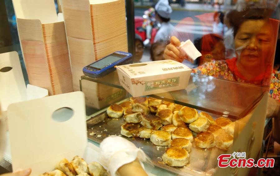 Customers queue to buy mooncakes for the upcoming Mid-Autumn Festival at a time-honored store in Shanghai, Sept. 12, 2018. The joyous Mid-Autumn Festival is celebrated on the fifteenth day of the eighth moon, Sept. 24 this year. Mooncakes are usually made with sweet fillings, such as nuts, mashed red beans, lotus-seed paste or Chinese dates, wrapped in a pastry. But the Shanghai store offers mooncakes with meat fillings, which prove to be very popular. (Photo: China News Service/Tang Yanjun)