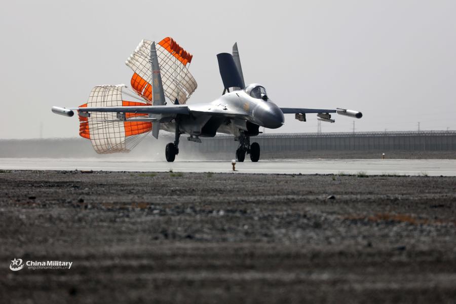 A J-11 fighter jet attached to an aviation brigade of the air force under the PLA Western Theater Command deploys its drogue parachute to slow itself after landing at a military airfield during the flight training exercise in the hinterland of the Kunlun Mountains in early September, 2018. (Photo/eng.chinamil.com.cn)