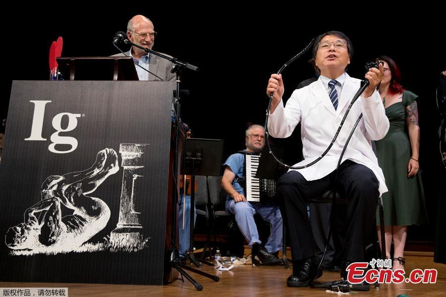 Akira Horiuchi, right of Japan, who won the Ig Nobel in medical education demonstrates his self colonoscopy technic during award ceremonies at Harvard University in Cambridge, Mass., Thursday, Sept. 13, 2018. The annual prize series honors 10 comical but practical scientific studies \
