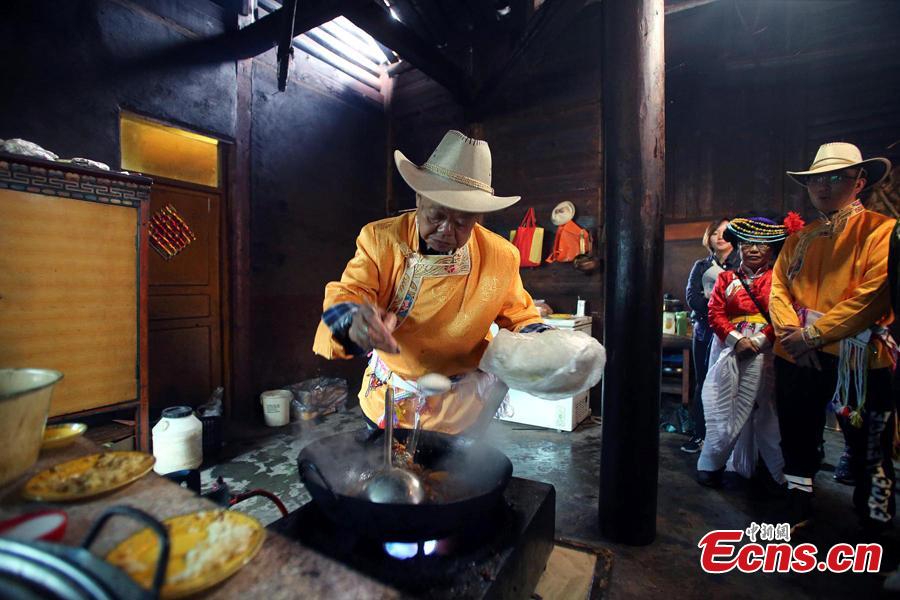 Sichuan cuisine master Fu Zuming (L) teaches cooking skills to a woman in a family of Mosuo people next to Lugu Lake in Yanyuan County, Southwest China’s Sichuan Province, Sept. 13, 2018. Fu started learning to cook Sichuan food in his teens. During his visit to the Mosuo family, he combined the local specialties with Sichuan cuisine techniques to make a new dish. (Photo: China News Service/Wang Lei)
