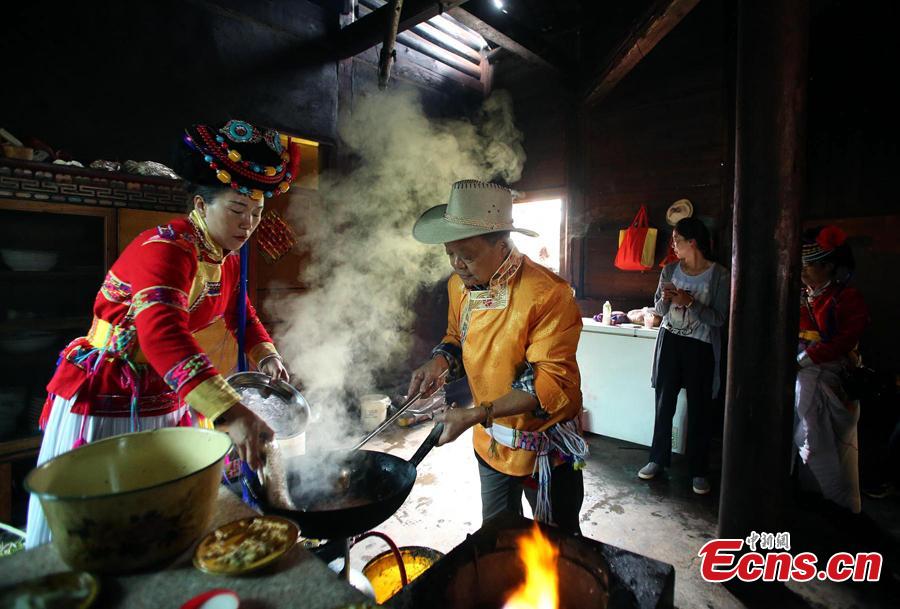 Sichuan cuisine master Fu Zuming (R) teaches cooking skills to a woman in a family of Mosuo people next to Lugu Lake in Yanyuan County, Southwest China’s Sichuan Province, Sept. 13, 2018. Fu started learning to cook Sichuan food in his teens. During his visit to the Mosuo family, he combined the local specialties with Sichuan cuisine techniques to make a new dish. (Photo: China News Service/Wang Lei)