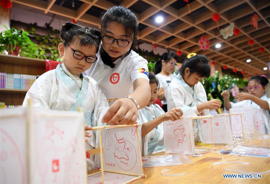 Children make lanterns to greet the upcoming Mid-Autumn Festival at a community in Hefei, capital of east China\'s Anhui Province, Sept. 15, 2018. (Xinhua/Liu Junxi)