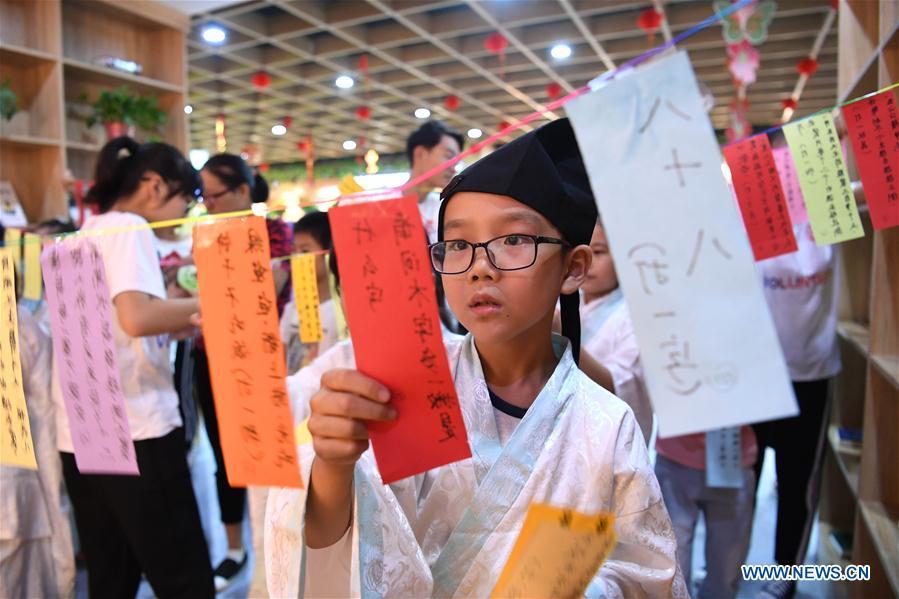 A child takes part in a lantern-riddle activity to greet the upcoming Mid-Autumn Festival at a community in Hefei, capital of east China\'s Anhui Province, Sept. 15, 2018. (Xinhua/Liu Junxi)