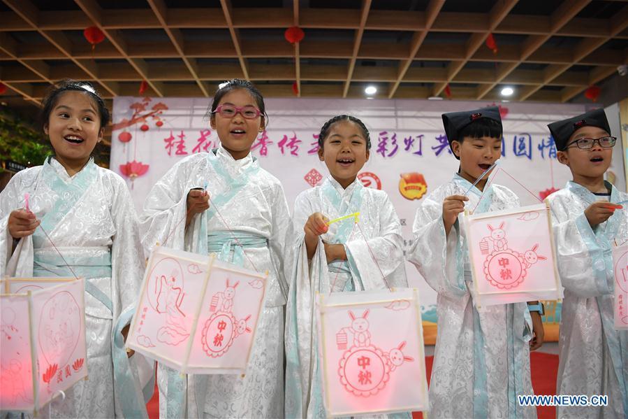 Children show lanterns they made to greet the upcoming Mid-Autumn Festival at a community in Hefei, capital of east China\'s Anhui Province, Sept. 15, 2018. (Xinhua/Liu Junxi)