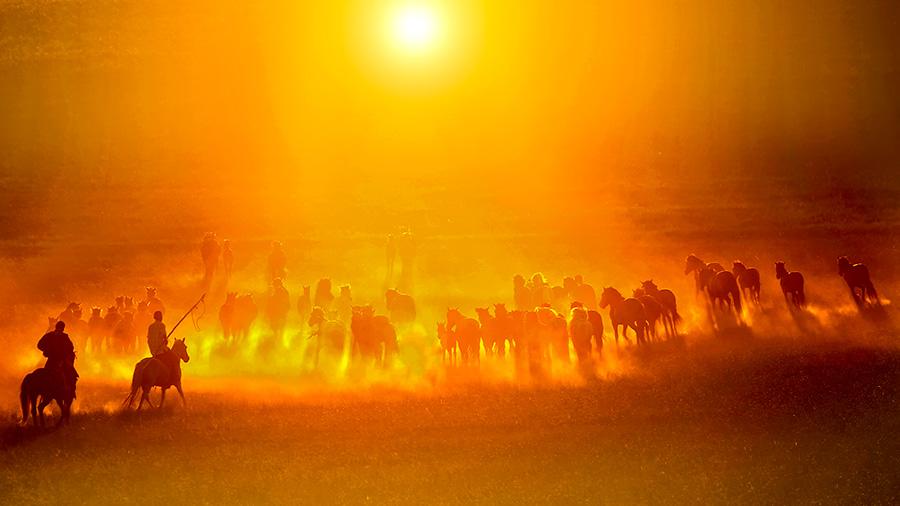 Autumn brings beautiful sunsets over open grasslands at Xilin Gol league in the Inner Mongolia autonomous region. Bathing in the sunset glow, working horses and herdsmen create a picturesque setting. (Photo/China Daily)