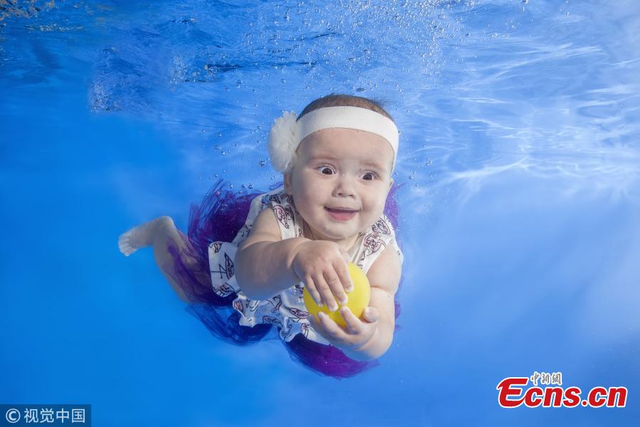 A baby girl swims underwater in a pool in Odessa, Ukraine. (Photo/VCG)