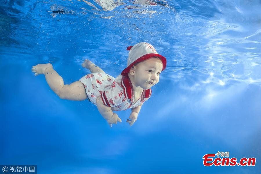 A baby girl swims underwater in a pool in Odessa, Ukraine. (Photo/VCG)