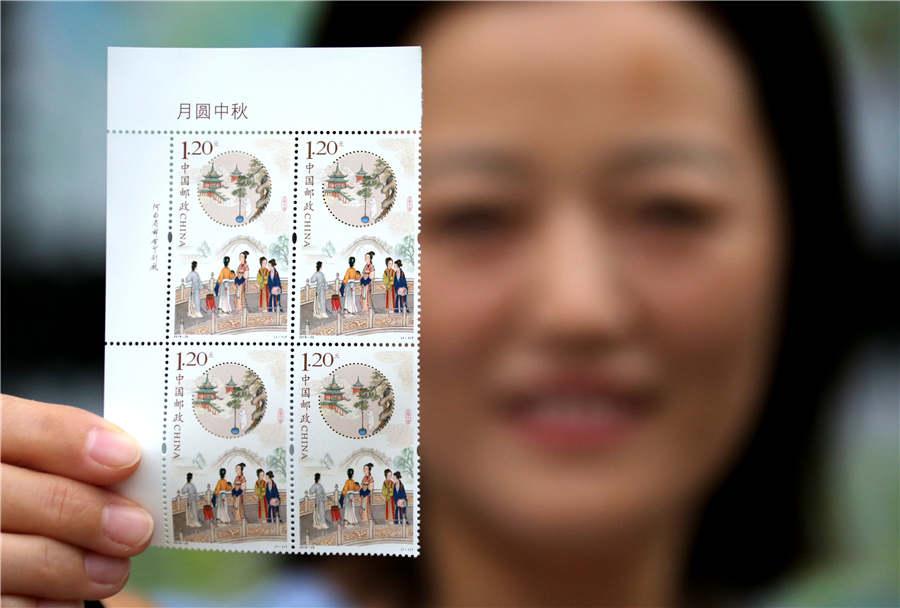 A stamp collector shows the newly issued stamp themed on the Mid-Autumn Festival, in Zaozhuang city, Shandong Province, Sept. 15, 2018. (Photo/Asianewsphoto)