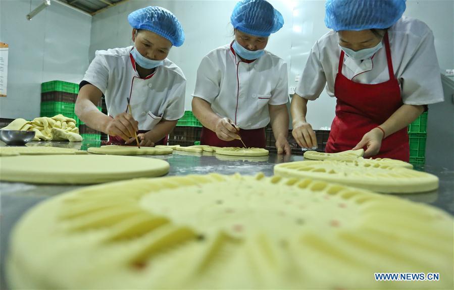 Staff make traditional moon cakes at a food processing workshop in Zhangye, northwest China\'s Gansu Province, on Sept. 18, 2018. Making traditional moon cakes before the Mid-Autumn Festival dates back to a thousand years in Zhangye. (Xinhua/Wang Jiang)