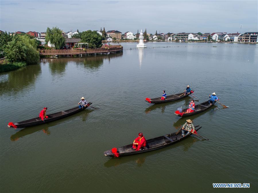 Aerial photo taken on Sept. 19, 2018 shows local people performing a wedding ceremony on Dingshan Lake of Tangqi Township in Hangzhou, capital of east China\'s Zhejiang Province. The locals held various folk activities to celebrate the coming of China\'s first Farmers\' Harvest Festival and the Mid-Autumn Festival. (Xinhua/Xu Yu)
