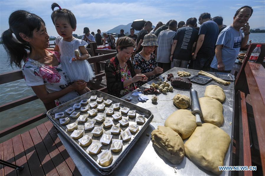 Staff members of a local cake shop make traditional moon cakes in Dinghe Village of Tangqi Township in Hangzhou, capital of east China\'s Zhejiang Province, Sept. 19, 2018. The locals held various folk activities to celebrate the coming of China\'s first Farmers\' Harvest Festival and the Mid-Autumn Festival. (Xinhua/Xu Yu)