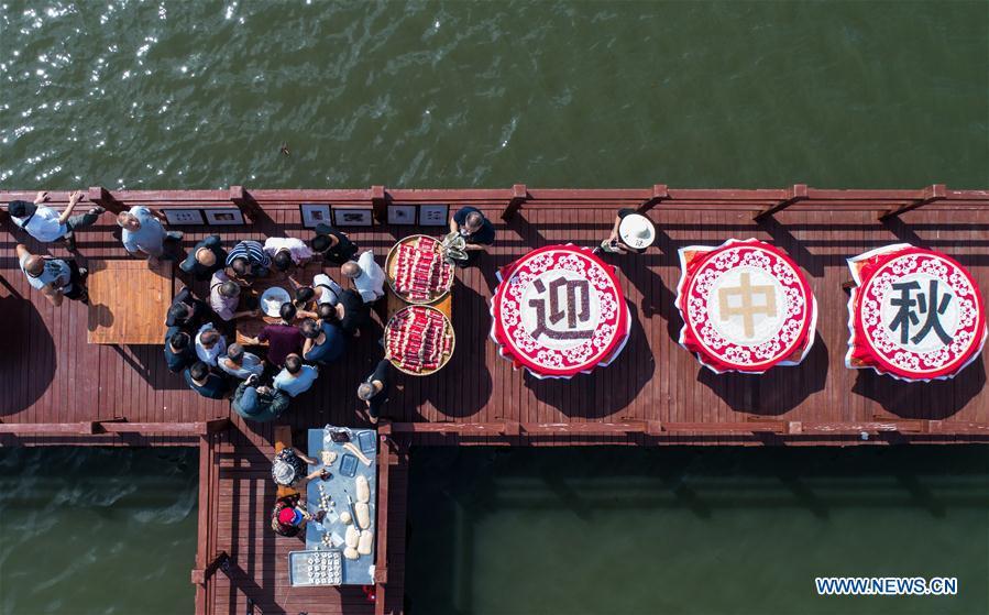 Aerial photo taken on Sept. 19, 2018 shows local people attending a folk activity in Dinghe Village of Tangqi Township in Hangzhou, capital of east China\'s Zhejiang Province. The locals held various folk activities to celebrate the coming of China\'s first Farmers\' Harvest Festival and the Mid-Autumn Festival. (Xinhua/Xu Yu)