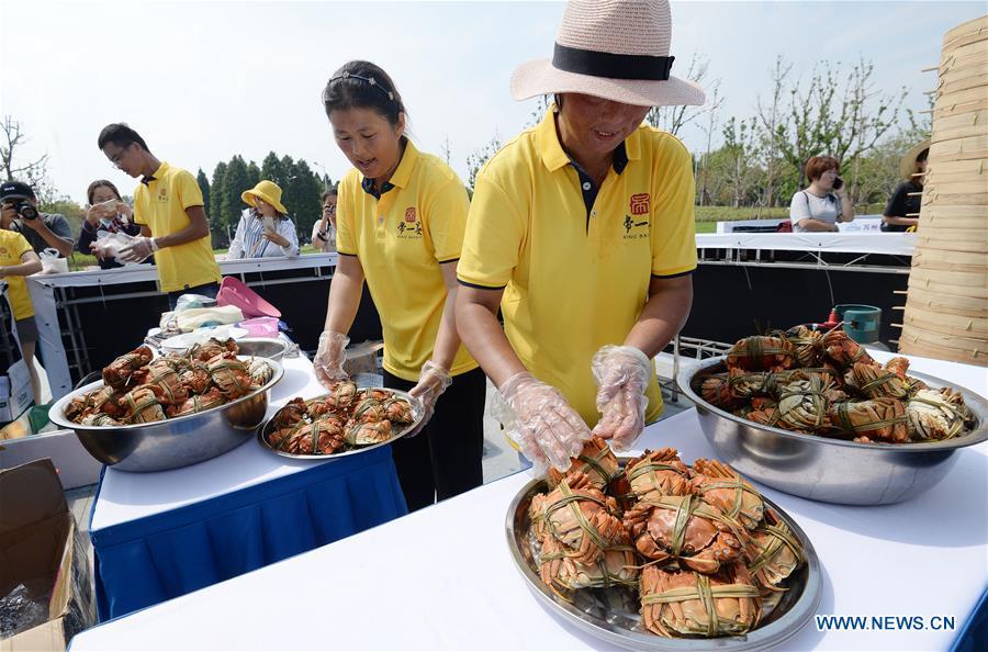 Staff members prepare dishes made from Chinese mitten crabs during a tourist festival held ashore the Yangcheng Lake in Xiangcheng District of Suzhou, east China\'s Jiangsu Province, Sept. 19, 2018. The Chinese mitten crabs inhabiting Suzhou\'s Yangcheng Lake are a popular cooking ingredient for many food lovers. In the annual event which kicked off here on Wednesday, tourists will be able to have a taste of this year\'s first Chinese mitten crabs ready to serve the table, while the official netting of Yangcheng Lake crabs will begin on Sept. 21. (Xinhua/Hao Qunying)