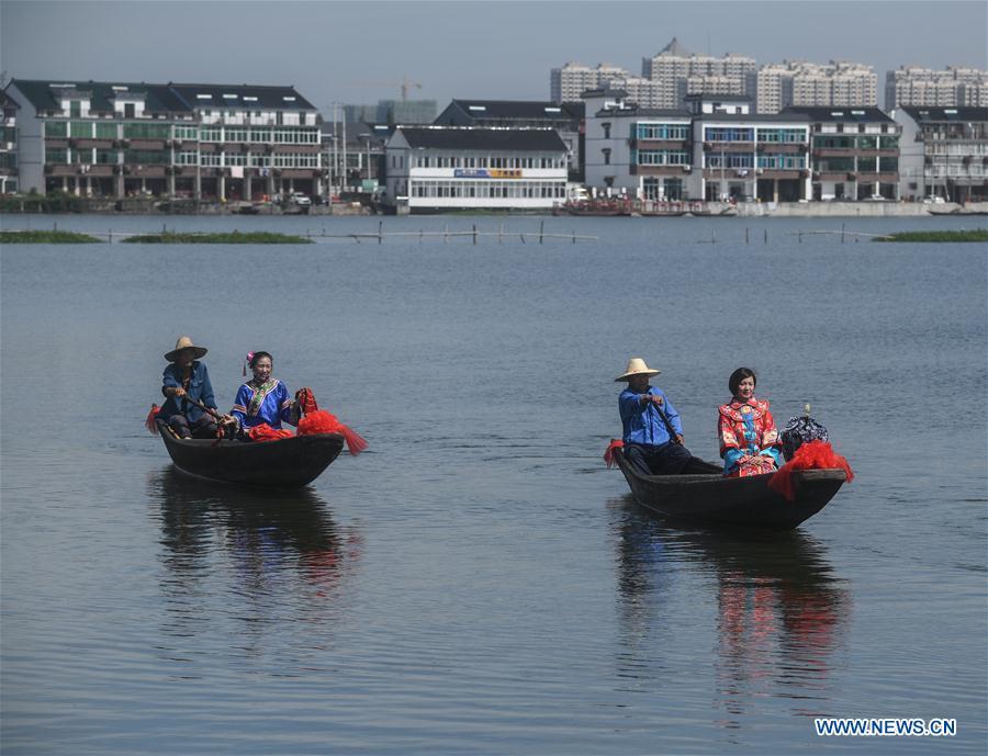 Local people perform a wedding ceremony on Dingshan Lake of Tangqi Township in Hangzhou, east China\'s Zhejiang Province, Sept. 19, 2018. The locals held various folk activities to celebrate the coming of China\'s first Farmers\' Harvest Festival and the Mid-Autumn Festival. (Xinhua/Xu Yu)