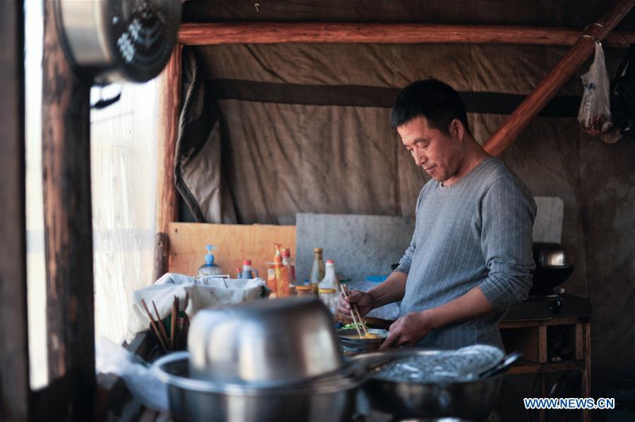 Forester Wang Liang prepares lunch in Yue\'anli Forest Farm of Genhe forestry bureau in the Greater Khingan Mountains of north China\'s Inner Mongolia Autonomous Region, Sept. 18, 2018. Staff members at Yue\'anli Forest Farm are responsible for the conservation and breeding work of reindeer in China. (Xinhua/Yu Yang)