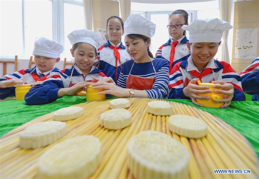 Students learn to make mooncakes at Nanguan primary school to greet the traditional Mid-Autumn Festival in Handan City, north China\'s Hebei Province, Sept. 21, 2018. The Mid-Autumn Festival falls on the 15th day of the eighth month of the Chinese lunar calendar, or Sept. 24 this year. (Xinhua/Wang Xiao)