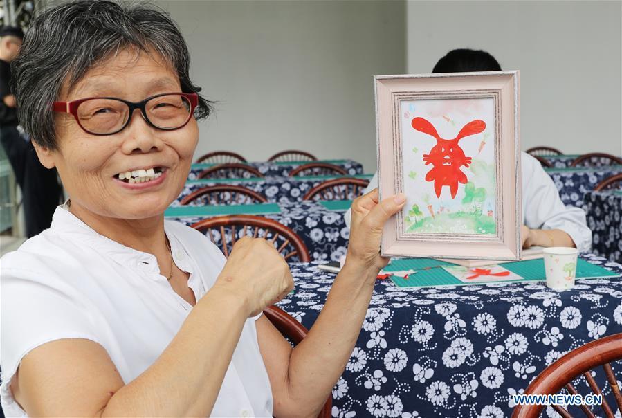 A citizen shows her paper cutting work during a series of activities held to greet Mid-Autumn Festival in Shanghai, east China, Sept. 22, 2018. The Chinese traditional Mid-Autumn Festival falls on the 15th day of the eighth month on the Chinese lunar calendar, which is Sept. 24 this year. (Xinhua/Fang Zhe)