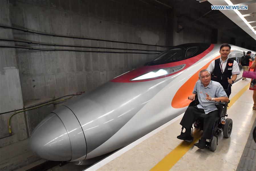 Passengers pose with train G5736 at West Kowloon Station in Hong Kong, south China, Sept. 23, 2018. Train G5736 left Hong Kong West Kowloon Station at 7:00 on Sunday (1100 GMT Saturday) for Shenzhen North Railway Station. At 6:44, train G5711 left Shenzhen North Railway Station for Hong Kong West Kowloon Station, marking the opening of the Hong Kong section of the Guangzhou-Shenzhen-Hong Kong High-speed Railway and that of the whole Guangzhou-Shenzhen-Hong Kong High-speed Railway. (Xinhua/Lui Siu Wai)