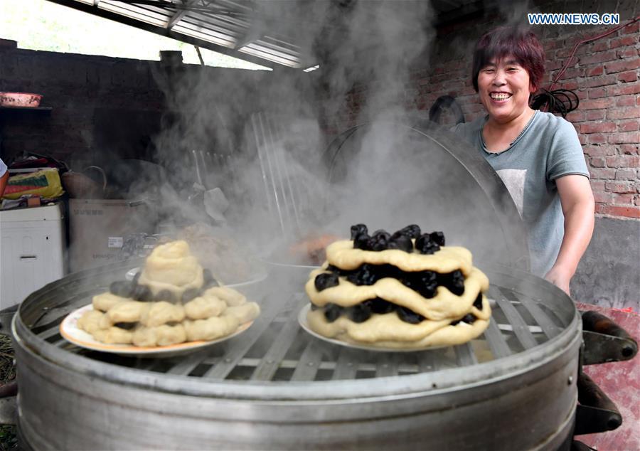 A villager prepares steamed pastries for a harvest party in Peiligang Village of Xinzheng, central China\'s Henan Province, Sept. 14, 2018. China will mark its first Farmers\' Harvest Festival on Sept. 23 this year. From 2018 on, the festival, to be celebrated on the Autumnal Equinox each year, is set to be observed annually to greet the harvest season and honour the agricultural workers. (Xinhua/Li An)