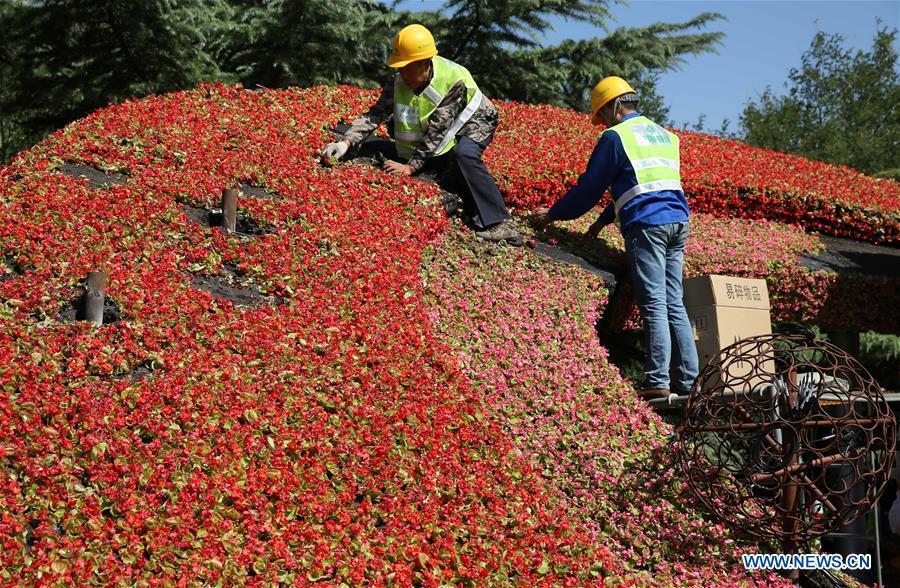 Workers arrange flowers for a decorating parterre in Beijing, capital of China, Sept. 21, 2018. Decorating parterres are set up in Beijing to greet the National Day, which falls on Oct. 1. (Xinhua/Liang Zhiqiang)