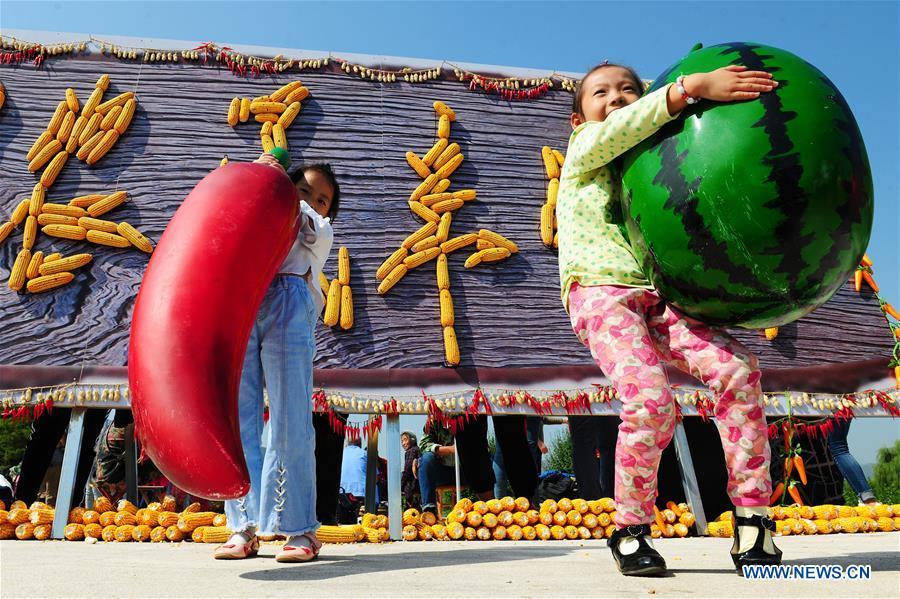 Two girls participate in an activity marking China\'s first Farmers\' Harvest Festival in Zibo, east China\'s Shandong Province, Sept. 23, 2018. People across China hold various activities to celebrate the country\'s first Farmers\' Harvest Festival, which falls on Sept. 23 this year. (Xinhua/Liu Bingyou)