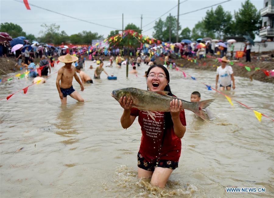 A girl shows a fish she has caught in a bare-hand fish catching contest held in Housangyuan Village of Lyutan Township Wuyi County, east China\'s Zhejiang Province, Sept. 23, 2018. People across China hold various activities to celebrate the country\'s first Farmers\' Harvest Festival, which falls on Sept. 23 this year. (Xinhua/Zhang Jiancheng)